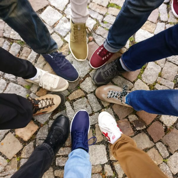 Circle of different feet and shoes to represent UDL philosophy that one size does not fit all.